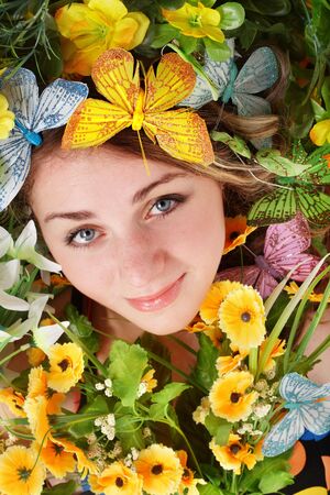  Beautiful girl with butterfly and flower on green grass. Outdoor.の写真素材