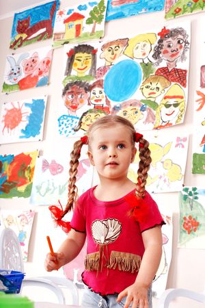  Child with picture and brush in playroom. Preschool.の写真素材