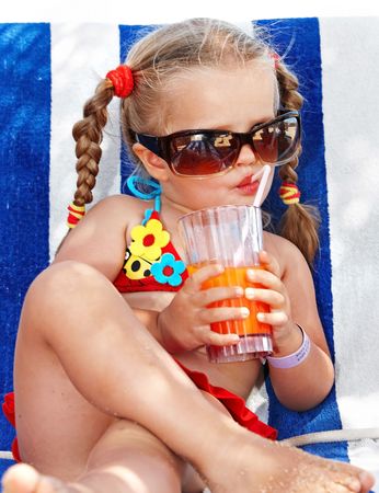 Child girl in glasses and red bikini drink juice.の写真素材