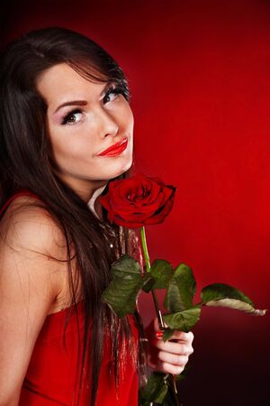 Girl with rose on red background. Valentines day.の写真素材