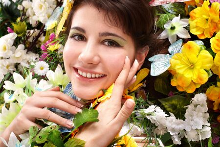 Beautiful girl with butterfly and flower on grass. Outdoor.の写真素材