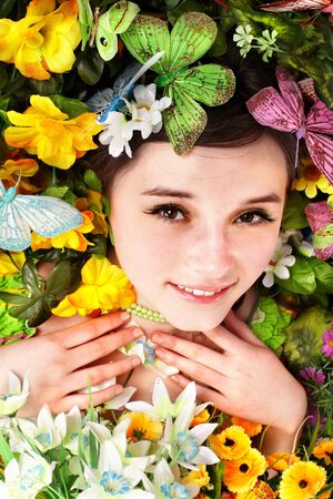  Beautiful girl with butterfly and flower on green grass. Outdoor.の写真素材