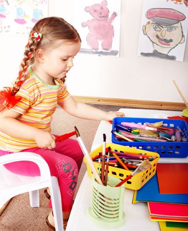 Child prescooler with colour pencil in play room.の写真素材