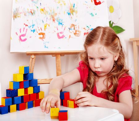  Child with wood block and construction set in play room. Preschool.の写真素材