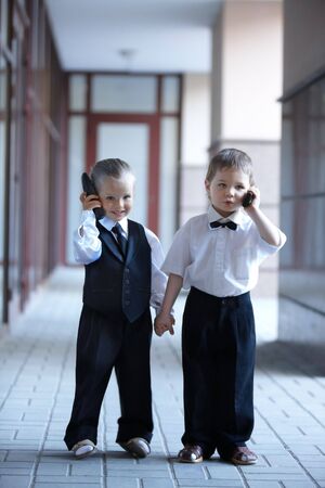 Children in business suit with mobile phone outdoors. Concept.の写真素材