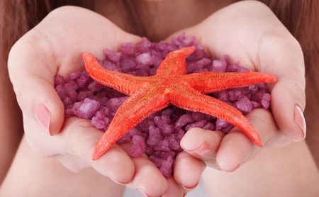 Closeup of hand with sea salt. Spa product.の写真素材