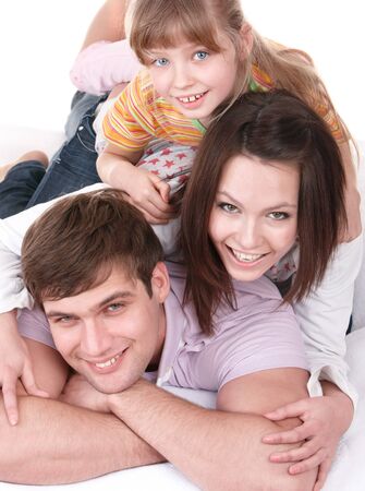 Happy family on white bed. Isolated.の写真素材