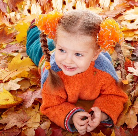 Girl child in autumn orange leaves. Outdoor.の写真素材