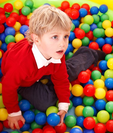 Little boy in colourful balls.  Playground.の写真素材
