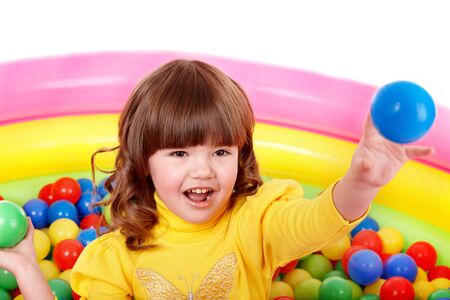 Happy little girl play in group colourful ball.の写真素材