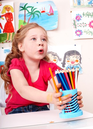 Child prescooler with pencil in play room.の写真素材