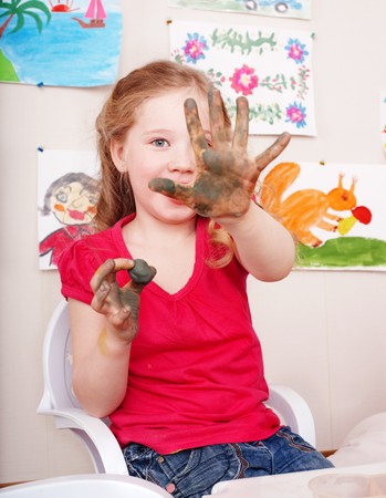 Little girl playing with clay in play room.の写真素材