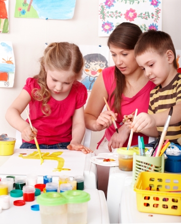 Children painting with teacher. Child development.の写真素材