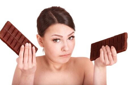 Beautiful young womanl eating chocolate bar. Isolated.の写真素材