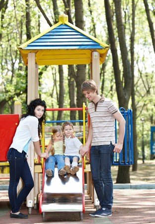 Outdoor happy family with children on slide.の写真素材