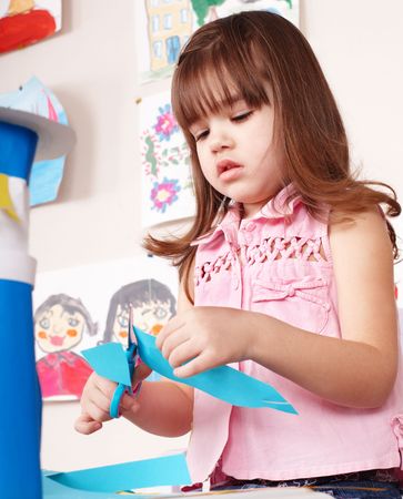 Serious child cutting paper by scissors.の写真素材