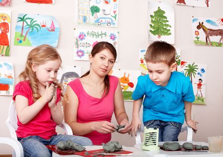 Children playing  with teacher from clay. Child development.の写真素材