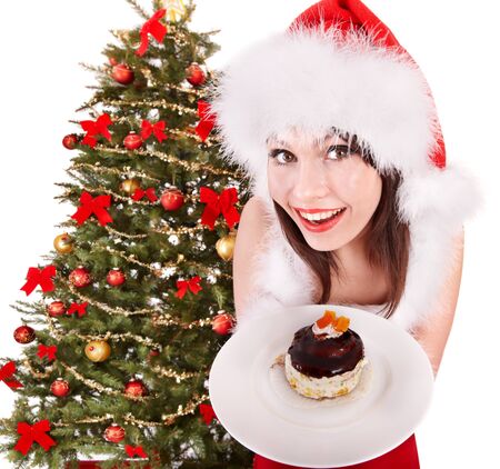 Christmas girl in red santa hat eating cake on plate. Isolated.の写真素材