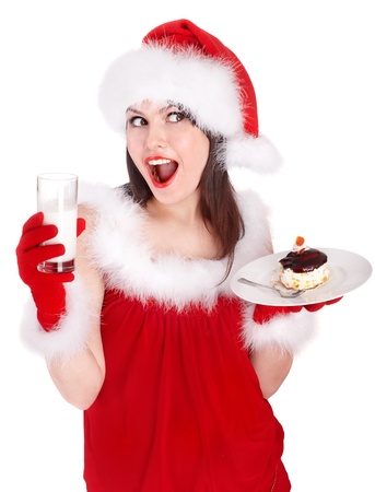 Christmas girl in red santa hat eating cake on plate. Isolated.の写真素材
