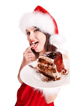 Christmas girl in red santa hat eating cake on plate. Isolated.の写真素材