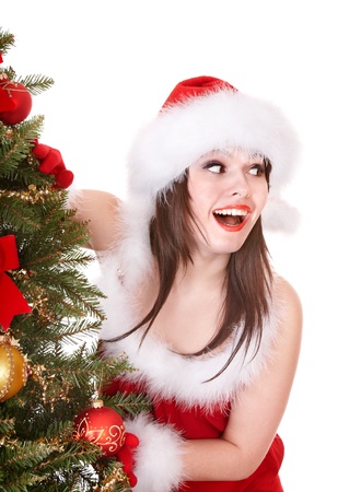 Girl in santa hat holding gift box near christmas tree.  Isolated.の写真素材