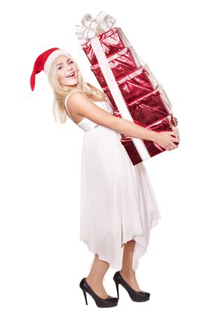 Christmas girl in santa hat holding stack red gift box. Isolated.の写真素材