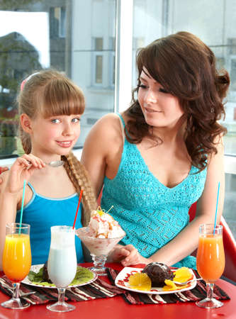 Happy mother and daughter in restaurant.の写真素材