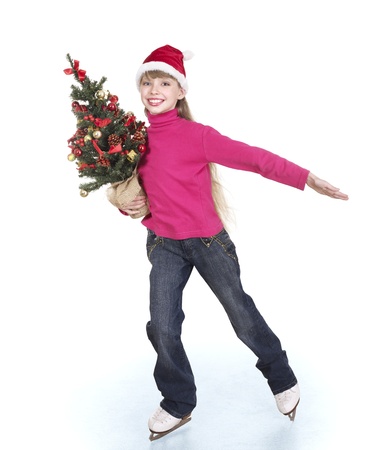 Happy young girl figure skating with christmas tree.. Isolated.の写真素材