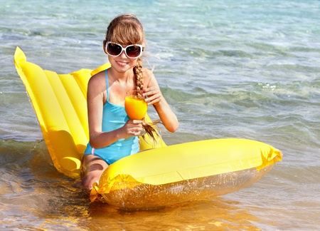 Little girl swimming on inflatable beach mattress.の写真素材