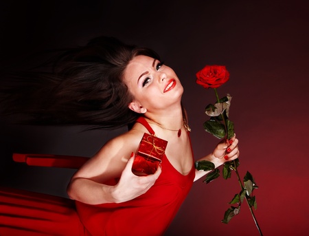 Girl with flower rose and gift box running. Valentines day.の写真素材
