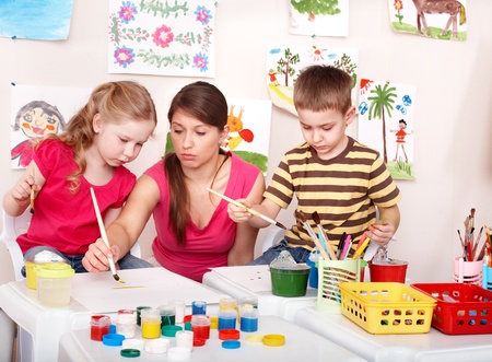 Children with teacher painting in play room. Preschool.の写真素材