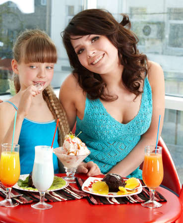 Happy mother and daughter in restaurant.の写真素材