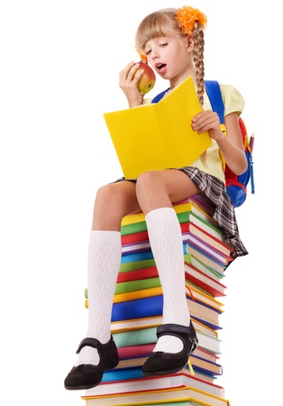 Schoolgirl sitting on pile of books. Isolated.の写真素材