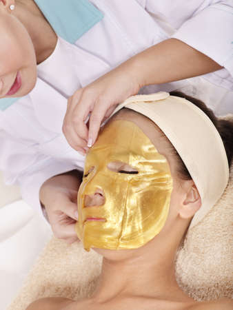 Young womanl with gold facial mask.の写真素材
