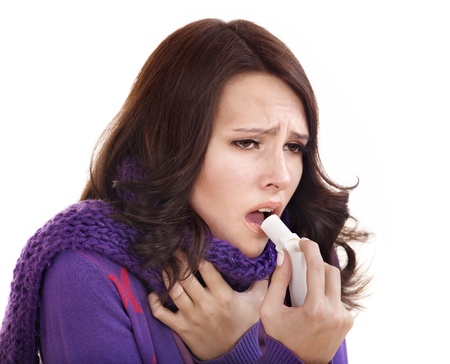Young woman using throat spray.の写真素材