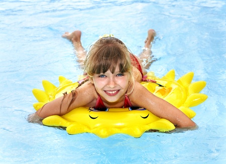 Children  on inflatable ring in swimming pool.の写真素材