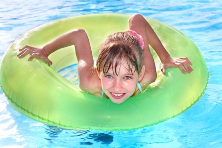 Children sitting on inflatable ring in swimming pool.の写真素材