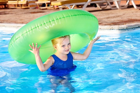 Children holding inflatable ring in swimming pool.の写真素材