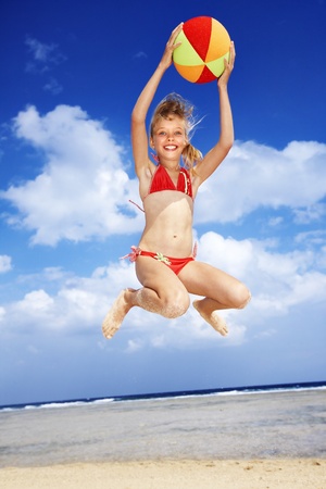 Little girl  playing on  beach with ball.の写真素材