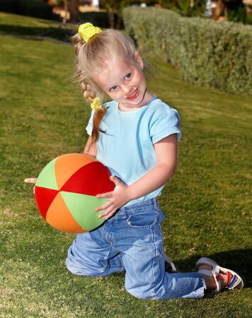 little girl play with red ball in  parkの写真素材