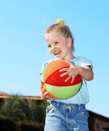 little girl play with red ball in  parkの写真素材