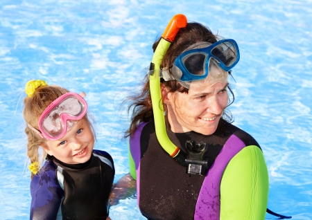 Child with mother in swimming pool learning snorkeling.の写真素材
