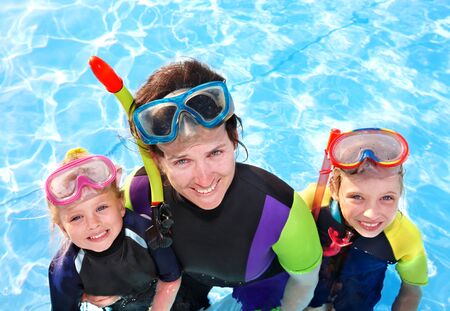 Children with mother  in swimming pool learning snorkeling.の写真素材