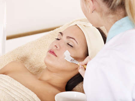 Beautician applying  facial mask by young woman.の写真素材