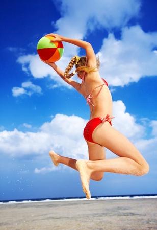 Little girl  playing on  beach with ball.の写真素材