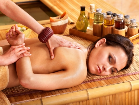 Young woman getting massage in bamboo spa.の写真素材