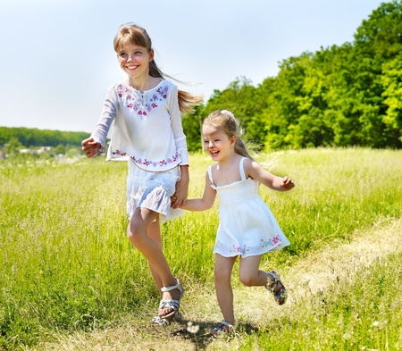 Group children running across green grass outdoor. の写真素材