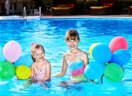 little girl playing with balloons in swimming pool.の写真素材