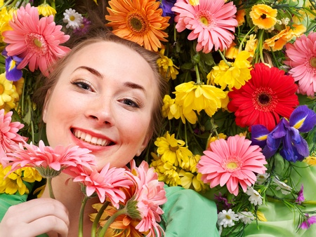 Beautiful young woman in flowers touching face.の写真素材