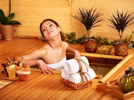 Young woman getting massage in bamboo spa.の写真素材